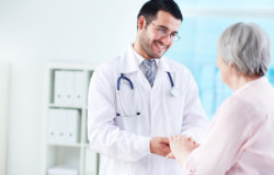 Confident doctor looking at his senior patient while speaking to