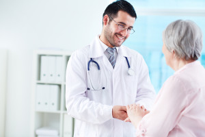 Confident doctor looking at his senior patient while speaking to her